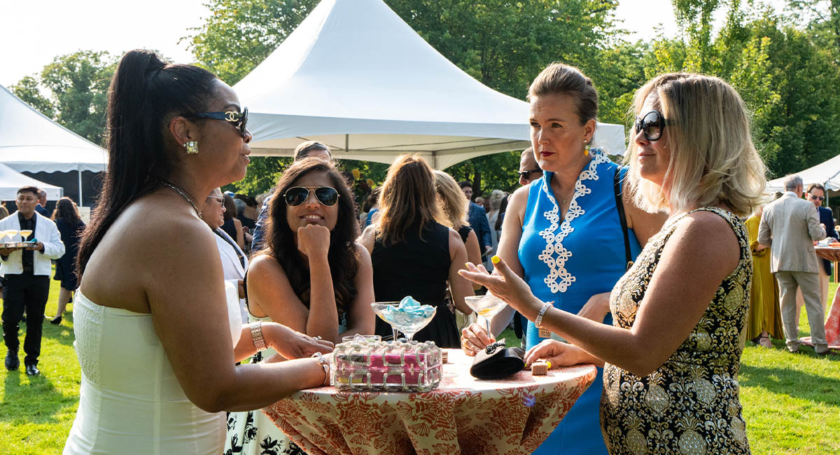 Four women conversing outdoors at a high-top table at Ravinia's Gala fundraising event