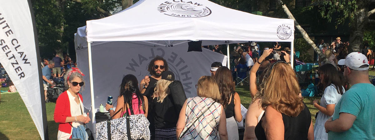 Ravinia guests sampling White Claw Hard Selzer drinks at a sponsored tent inside the park at a concert