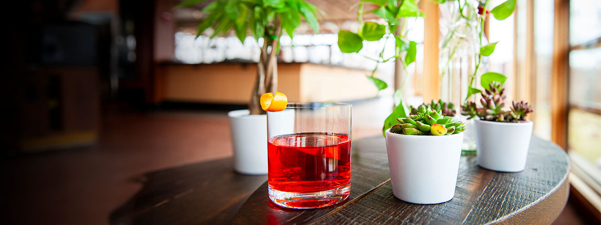 Signature cocktail on a rustic wooden table in the Tree Top Lounge